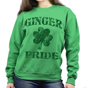 Puede incluir: Una sudadera verde con las palabras "GINGER PRIDE" en letras verde oscuro desgastadas. Un tr&eacute;bol verde oscuro est&aacute; centrado entre las palabras. La sudadera es de cuello redondo.