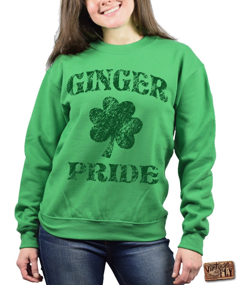 Puede incluir: Una sudadera verde con las palabras "GINGER PRIDE" en letras verde oscuro desgastadas. Un tr&eacute;bol verde oscuro est&aacute; centrado entre las palabras. La sudadera es de cuello redondo.