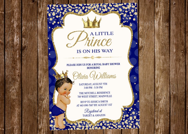 Puede incluir: Una invitaci&oacute;n a una fiesta de bienvenida al beb&eacute; de color azul real y dorado con una ilustraci&oacute;n de dibujos animados de un beb&eacute; var&oacute;n con una corona. La invitaci&oacute;n dice "A Little Prince Is On His Way" e incluye los detalles del evento, incluida la fecha, la hora, el lugar y la informaci&oacute;n de RSVP. La invitaci&oacute;n tambi&eacute;n incluye el texto "Registered at Target & Amazon".