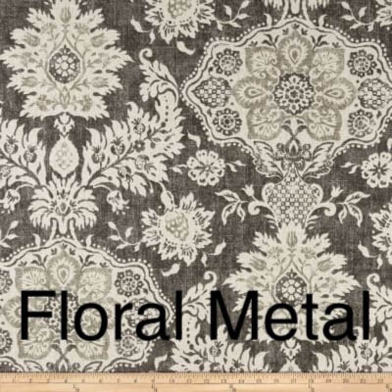 May include: Close-up of a fabric with a repeating floral pattern in shades of gray and off-white. The words "Floral Metal" are printed across the bottom of the fabric. The fabric has a textured appearance.