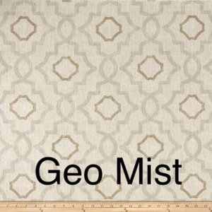 May include: Cream-colored fabric with a geometric pattern in light gray and tan. The design features interlocking shapes and the text "Geo Mist" in black. A wooden ruler is at the bottom.