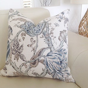 May include: A decorative throw pillow with a floral pattern in shades of blue, brown, and white. The pillow is made of a soft, linen-like fabric and features a delicate floral design.