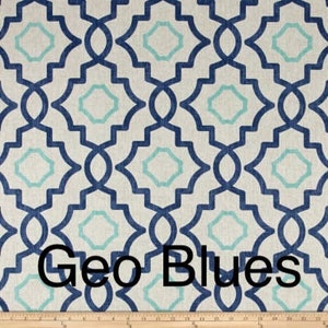 May include: Geometric patterned fabric in shades of blue and teal on a cream background. The design features interlocking shapes, with the text "Geo Blues" at the bottom. A wooden ruler is at the bottom of the image.
