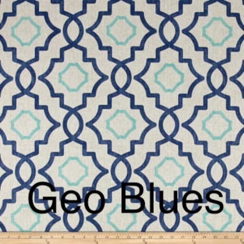 May include: Geometric patterned fabric in shades of blue and teal on a cream background. The design features interlocking shapes, with the text "Geo Blues" at the bottom. A wooden ruler is at the bottom of the image.