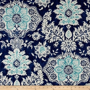 May include: Dark blue fabric with a repeating floral pattern in white and teal. The design features large, ornate floral medallions and smaller floral and leaf motifs. The fabric has a textured appearance, suggesting a woven material.
