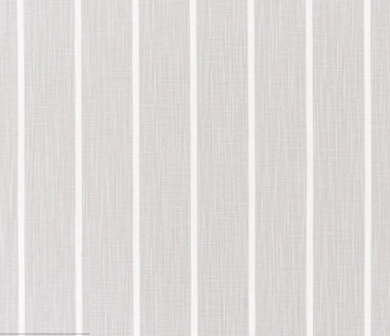 May include: A close-up of a white fabric with vertical stripes. The fabric has a subtle texture.