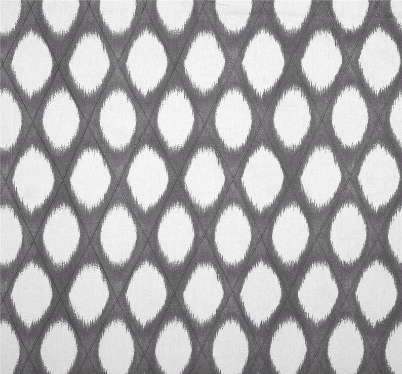 May include: A white and gray fabric with a repeating pattern of large, white, fuzzy circles on a gray background.