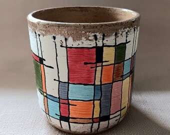 Stain Glass Sketch of lines and colors on a white bacground of porcelain over a speckled red clay universal cup planter utensil holder