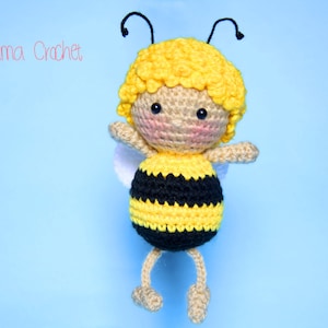 Pode incluir: Um brinquedo de abelha de crochê com listras amarelas e pretas, uma cabeça amarela e olhos pretos. A abelha tem pequenas asas e antenas.