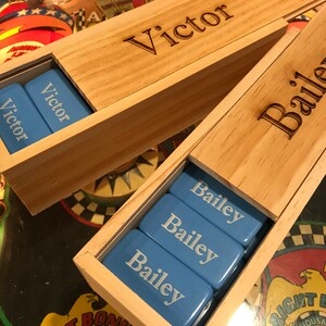 May include: Two wooden boxes with blue tiles inside. The boxes are personalized with the names "Victor" and "Bailey".