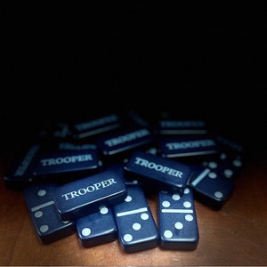 May include: A pile of blue dominoes with white dots. Each domino has the word "TROOPER" printed on it.