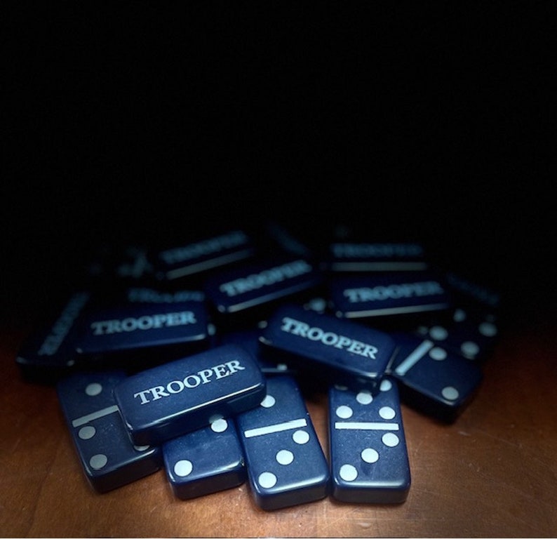 May include: A pile of blue dominoes with white dots. Each domino has the word "TROOPER" printed on it.