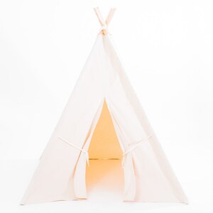 May include: A white canvas teepee tent for kids, with a flap open to reveal the interior. The teepee is made of soft, natural fabric and has a simple, classic design.