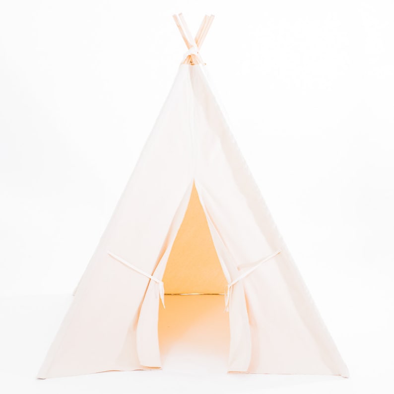 May include: A white canvas teepee tent for kids, with a flap open to reveal the interior. The teepee is made of soft, natural fabric and has a simple, classic design.
