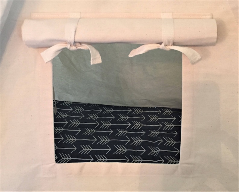 May include: A white canvas tent with a roll-up window. The window is open and shows a black and white fabric with a pattern of arrows.