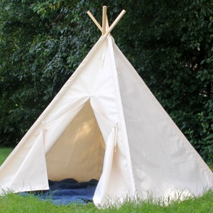 May include: A white canvas teepee tent with wooden poles, set up in a grassy area. The tent has a flap that can be opened and closed.