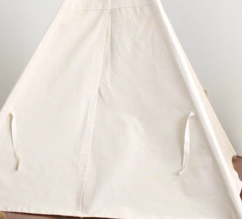 Puede incluir: Una tienda de campa&ntilde;a tipi de lona blanca con lazos blancos en los lados.