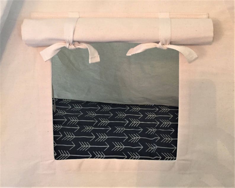 May include: A white canvas tent with a roll-up window. The window is open and shows a black and white fabric with a pattern of arrows.
