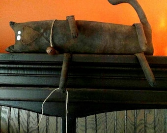 Phooey, our primitive black cat playing with his mouse friend