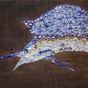 May include: A blue and silver marlin fish made from bottle caps. The fish is mounted on a wooden background.
