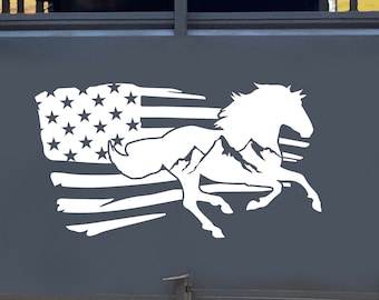Puede incluir: Un remolque de caballos gris con una silueta blanca de un caballo corriendo a través de una bandera estadounidense. El caballo corre hacia la derecha y la bandera ondea al viento.