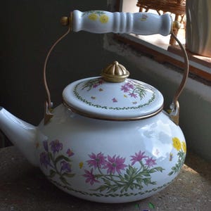 May include: A set of three ceramic nesting bowls in shades of blue, green, and white. The bowls feature a speckled glaze and a simple, modern design. The largest bowl measures approximately 8 inches in diameter.