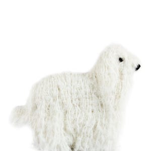 May include: A white fluffy sheep plush toy. The sheep is lying down with its head turned to the side.