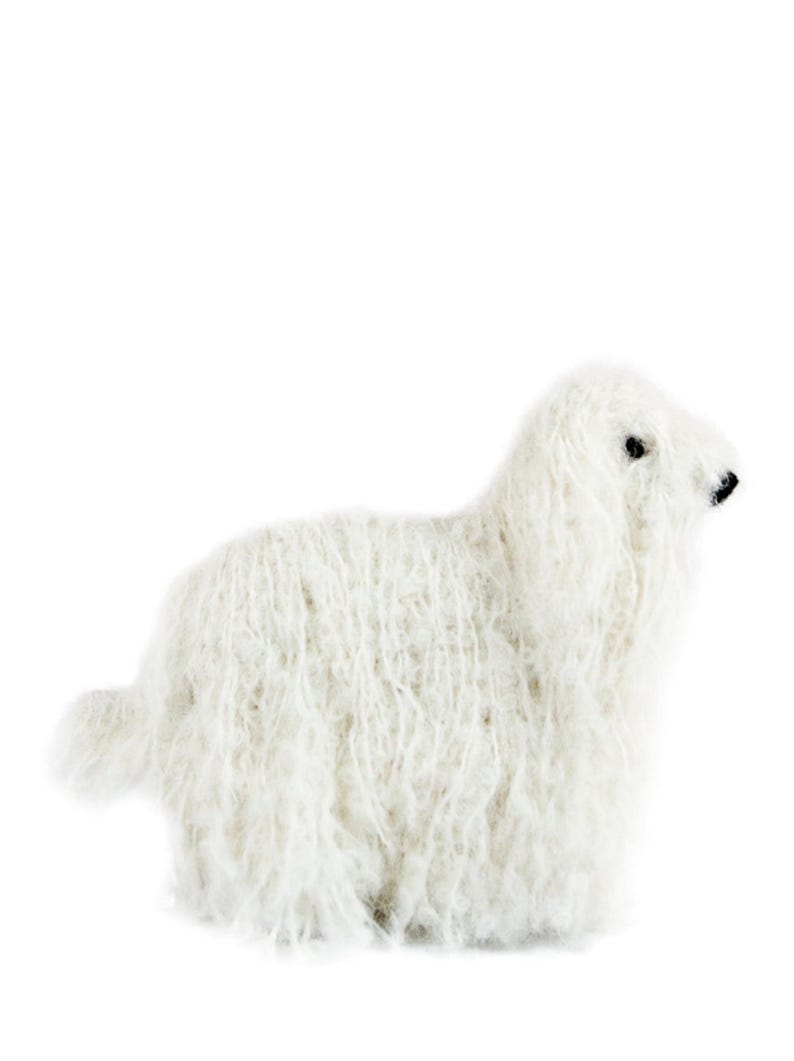 May include: A white fluffy sheep plush toy. The sheep is lying down with its head turned to the side.