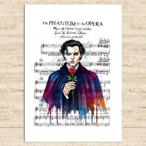 May include: A print featuring a watercolor illustration of the Phantom of the Opera. The Phantom is depicted with a half-mask, holding a red rose, set against a backdrop of musical notes and text. The title "The Phantom of the Opera" is displayed at the top.