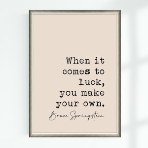 Könnte beinhalten: Ein beiger druckbarer Zitat-Poster mit schwarzem Rahmen. Das Zitat lautet "When it comes to luck, you make your own." und wird Bruce Springsteen zugeschrieben.