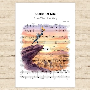 Peut inclure: Une impression de partition de musique pour "Circle of Life" du Roi Lion, avec une illustration à l'aquarelle de la scène emblématique. L'image comprend le texte "Circle Of Life", "from The Lion King" et "Elton John".