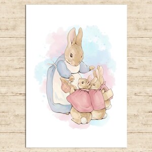 Pode incluir: Ilustração em aquarela de uma coelha mãe com vestido e avental azuis, com três coelhinhos com capas rosas. O fundo apresenta suaves aguadas de aquarela azuis e rosas. A obra está sobre um fundo branco.