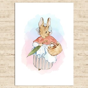 May include: Watercolor illustration of a rabbit wearing a red cape, bonnet, and striped dress, holding a green umbrella and a woven basket. The background features soft pink and blue watercolor washes. The artwork is on a white background.