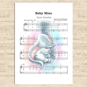 May include: A print of sheet music for "Baby Mine" from Dumbo, featuring a watercolor illustration of a mother elephant cradling a baby elephant. The background has soft pink and blue hues.