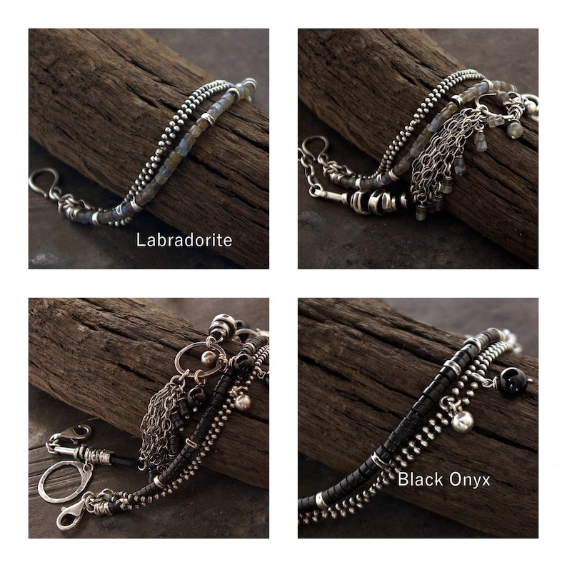 Op de afbeelding: Een armband met meerdere strengen, voorzien van zilverkleurige kettingen en kralen. Er zijn twee versies te zien: een met labradorietstenen en een met zwarte onyxkralen. Beide ontwerpen bevatten metalen bedels, zilverkleurige schakels en een sluiting.