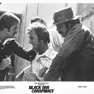 May include: Black and white photo of a scene from the movie "Black Oak Conspiracy".  The movie poster features the title of the film and the words "New World Pictures Presents".
