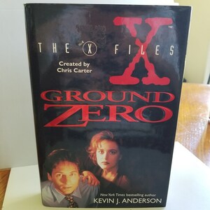 May include: A paperback book cover for "The X-Files: Ground Zero" by Kevin J. Anderson. The cover features a red "X" and the title in red text. The background is black and features a photo of the two main characters from the show.