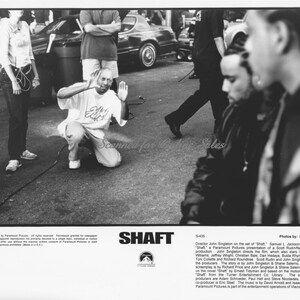 May include: A black and white promotional film still for the movie Shaft, featuring a director framing a shot on set with crew members nearby. The bottom section includes the film title Shaft, the Paramount logo, and detailed production text.