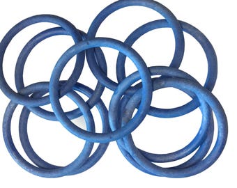 May include: A set of blue rubber rings interlocked together. The rings are all the same size and are arranged in a circular pattern.