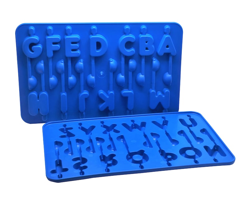 K&ouml;nnte beinhalten: Zwei blaue Silikonformen zur Herstellung von Leckereien in Buchstabenform. Die Formen zeigen die Buchstaben A bis H, mit Stielen in Form von Noten. Die Formen bestehen aus flexiblem, lebensmittelechtem Silikon.