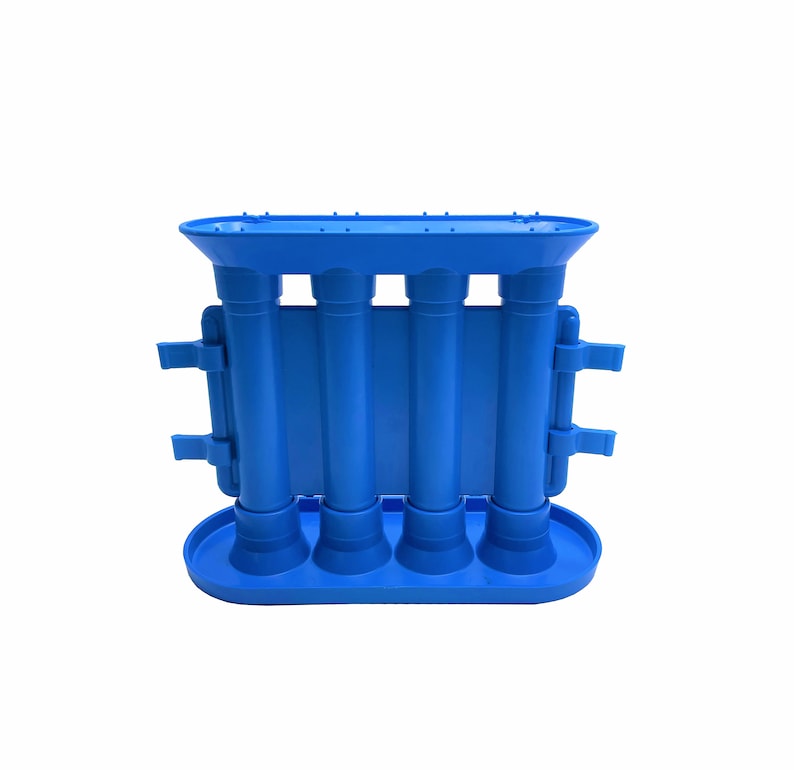 Peut inclure: Un moule en plastique bleu vif compos&eacute; de quatre chambres cylindriques verticales reli&eacute;es par un panneau central rectangulaire. La structure comprend une base ovale plate, un rebord sup&eacute;rieur assorti et deux petites languettes lat&eacute;rales.