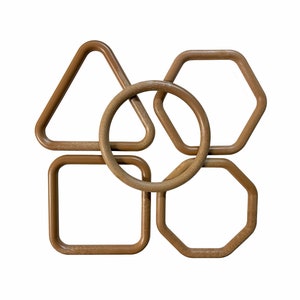 May include: Five brown wooden hoops of different shapes, including a circle, square, triangle, hexagon, and pentagon, are interlocked together.