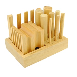 May include: A wooden set of geometric shapes, including cylinders, cubes, and rectangular prisms, with a wooden base labeled "WYNNIE BLOCK".