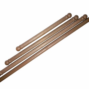 May include: Four wooden dowels with rounded ends, arranged diagonally. The dowels are light brown in colour and have a slightly rough texture.