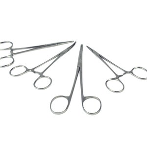 May include: Four stainless steel haemostats, surgical clamps, with a silver finish. The haemostats are arranged in a circle, with the tips of the clamps pointing towards the centre.