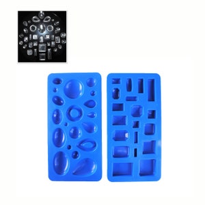 May include: Two blue silicone moulds for making resin jewellery. The mould on the left has 15 different shapes, including circles, ovals, teardrops, and more. The mould on the right has 14 different shapes, including squares, rectangles, and diamonds.