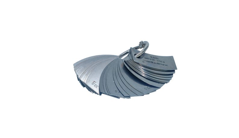 May include: A silver metal feeler gauge set with a ring handle. The gauge has a range of 0.005 to 0.500 inches. The gauge is used to measure the thickness of materials.