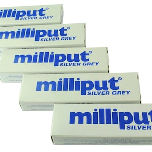 May include: Five boxes of Milliput Silver Grey epoxy putty. The boxes are stacked on top of each other, with the top box being the most visible. The boxes are white with blue lettering.