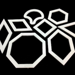 May include: Set of nine white plastic stencils in various geometric shapes, including a circle, square, diamond, triangle, and hexagon.
