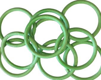 May include: A set of six green rubber rings interlocked together. The rings are all the same size and shape, and they are arranged in a random pattern.